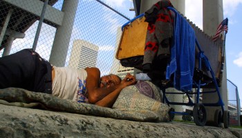 A person in Miami sleeps on a sidewalk in 2001.