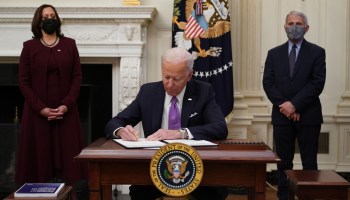 President Joe Biden signs executive orders as Vice President Kamala Harris and Dr. Anthony Fauci watch on Thursday.