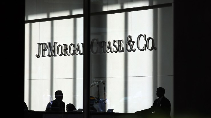 People pass a sign for JPMorgan Chase & Co. at its headquarters in Manhattan on Oct. 2, 2012, in New York City.