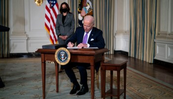 Vice President Kamala Harris looks on as President Joe Biden signs executive orders related to his racial equity agenda.