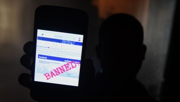A man using a mobile phone shows an image on Twitter that displays a blocked Facebook page in Colombo, Sri Lanka, on March 7, 2018.