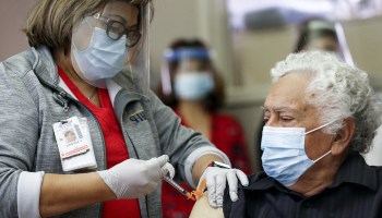A 72-year-old long-term care patient receives the Pfizer-BioNTech COVID-19 vaccine at Sharp Chula Vista Medical Center on Dec. 21, 2020, in Chula Vista, California.