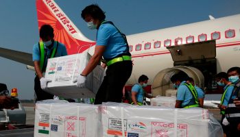 Workers unload cartons of coronavirus vaccine doses being delivered from India to Myanmar, at Yangon International Airport in Yangon on January 22, 2021.