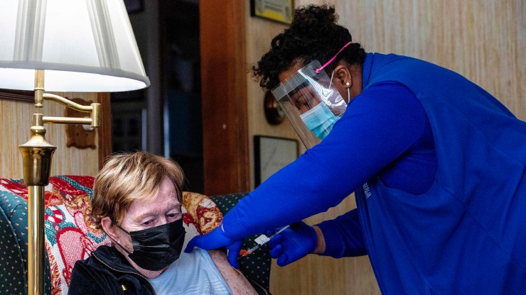 A registered nurse vaccinates an 83-year-old woman at her home in Manchester, Connecticut, on February 12, 2021.