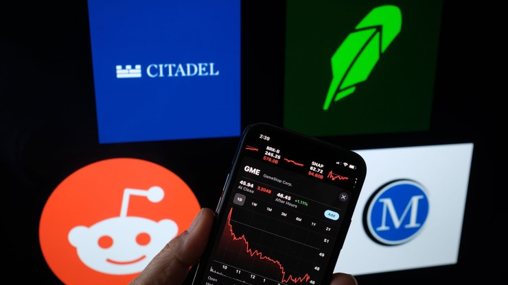 A person checks the GameStop stock with the Reddit, Citadel, Robinhood and Melvin Capital logos in the background in this photo illustration.