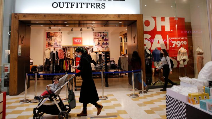 A person pushes a stroller past an American Eagle Outfitters at a mall.