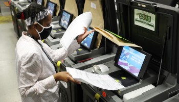 A Miami-Dade election worker feeds ballots into a voting machines during an accuracy test at the Miami-Dade Election Department headquarters on Oct. 14 in Doral, Florida.
