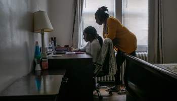 A 13-year-old student takes part in remote distance learning on a Chromebook with the help of her mother at home on October 28, 2020 in Stamford, Connecticut.