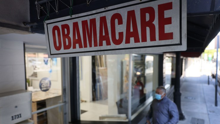 A pedestrian walks past the Leading Insurance Agency, which offers plans under the Affordable Care Act (also known as Obamacare) on January 28, 2021 in Miami, Florida.