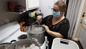 Marie Maybou melts snow on the kitchen stove on Feb. 19 in Austin, Texas. Maybou was using the water to flush the toilets in her home after the city water stopped running. Winter storm Uri brought historic cold weather, causing people to lose their water as pipes broke throughout the area.