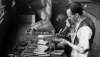 A man makes knives by hand circa 1932