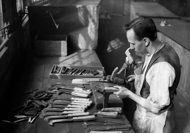 A man makes knives by hand circa 1932