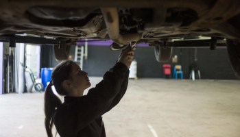 A woman mechanic fixes a car as she works in an innovative garage and auto repair workshop catering exclusively to female customers, in Saint-Ouen-l'Aumone, in the suburbs of Paris, on May 14, 2014.