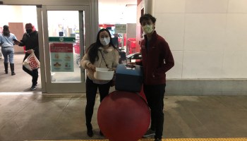 Dr. Thomas Lew, who is vaccinated, and his fiancee, Anne Li, who is not, at a Target store in San Francisco. They're thinking about whether to take a trip to Hawaii.