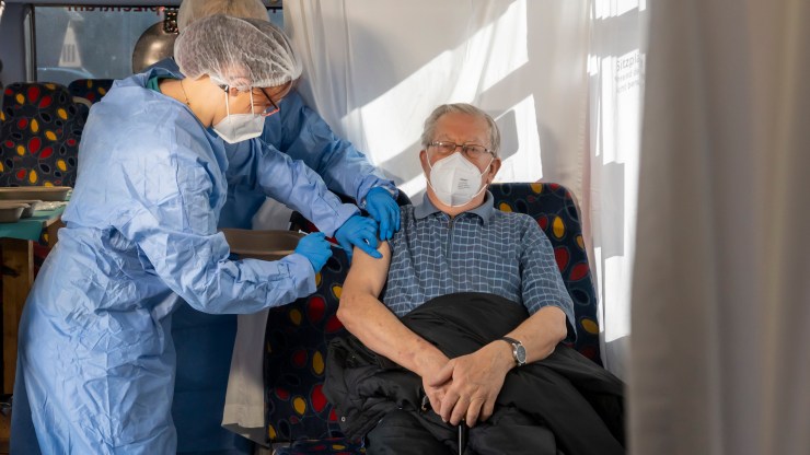 A nurse inoculates an elderly resident with the coronavirus vaccine.