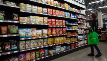 A shopper browses the snack aisle at a grocery store.