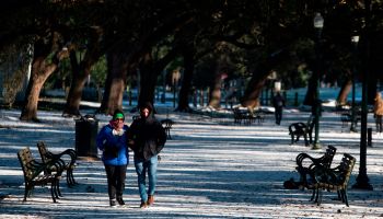 A couple walks through a snow-covered park in Houston.