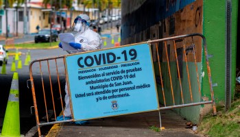 A medical worker stands at the entrance of a COVID-19 drive-thru testing site in San Juan, Puerto Rico, in March.