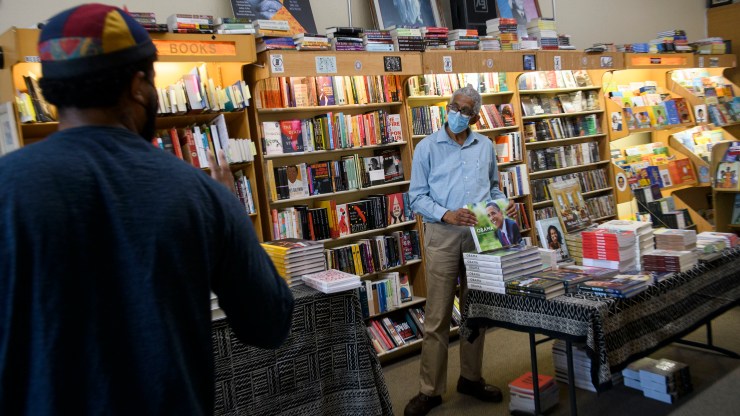 James Fugate, co-owner of Eso Won Books in Los Angeles, talks with a customer at his store.