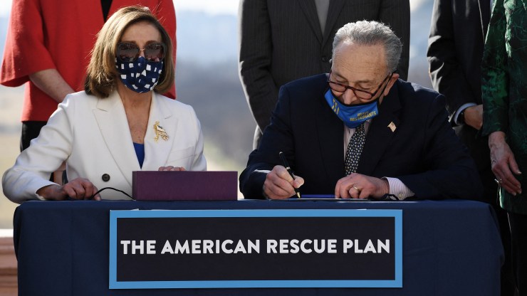 House Speaker Nancy Pelosi and Senate Majority Leader Chuck Schumer sign the American Rescue Plan Act on Wednesday. It will next move to the White House for President Biden's signature.