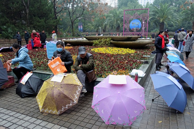Parents boast about their unmarried children's achievements on handwritten notes taped to umbrellas at Shanghai's People's Park. The ads bring China's urban-rural divide into sharp focus.