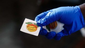 A polling place worker holds an "I'm a Georgia voter" sticker to hand to a voter on June 9, 2020 in Atlanta, Georgia.