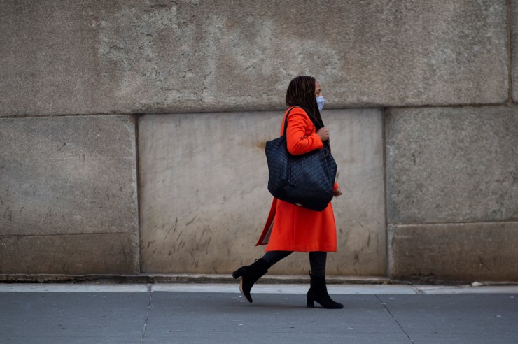 A woman walks in New York's financial district.