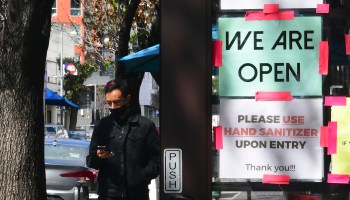 A "We Are Open" sign is seen on the side of a restaurant as indoor dining reopens in Los Angeles, on March 15, 2021.