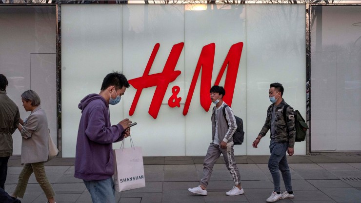 People walk by the flagship store of clothing brand H&M at a shopping area on March 25, 2021 in Beijing, China.
