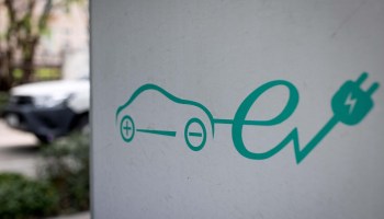 A sign for electric vehicle charging station is pictured at a parking area in Bangkok, Thailand, on March 30, 2021.