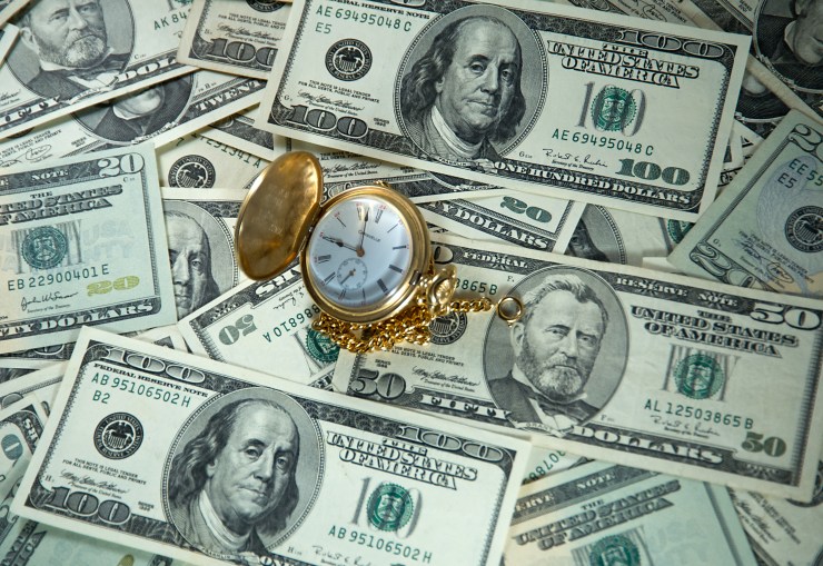 A photo illustration shows a pocket watch and US currency.