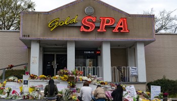 People bring flowers to a memorial site set up outside of the Gold Spa in Atlanta.