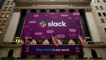 A Slack banner hangs out New York Stock Exchange.side the