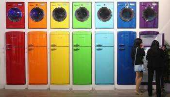 Visitors view brightly colored refrigerators and washing machines.