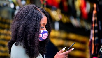 A woman wearing a face mask checks her cellphone in Los Angeles in November.