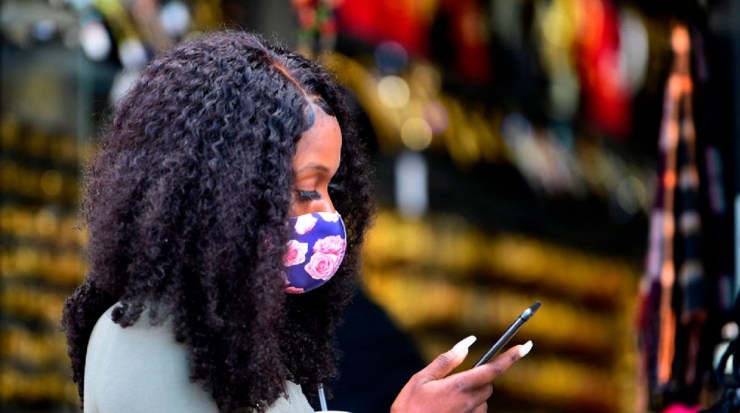 A woman wearing a face mask checks her cellphone in Los Angeles in November.