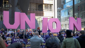 Labor activists hold signs forming the word "union" during a rally.