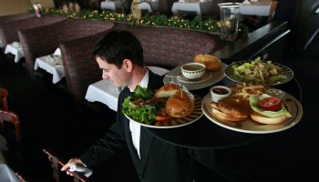 A waiter carries a tray of food.