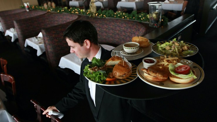 A waiter carries a tray of food.