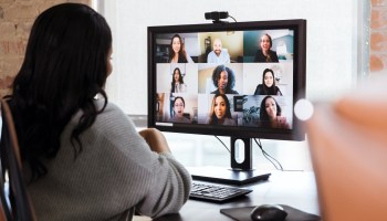 A businesswoman sees her colleagues on screen during a virtual meeting.