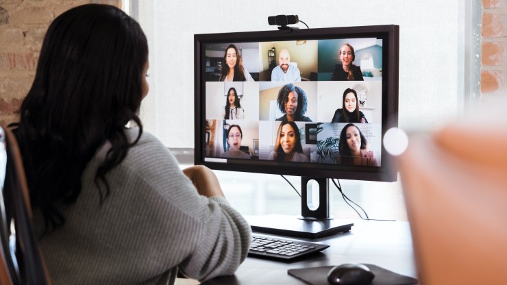 A businesswoman sees her colleagues on screen during a virtual meeting.