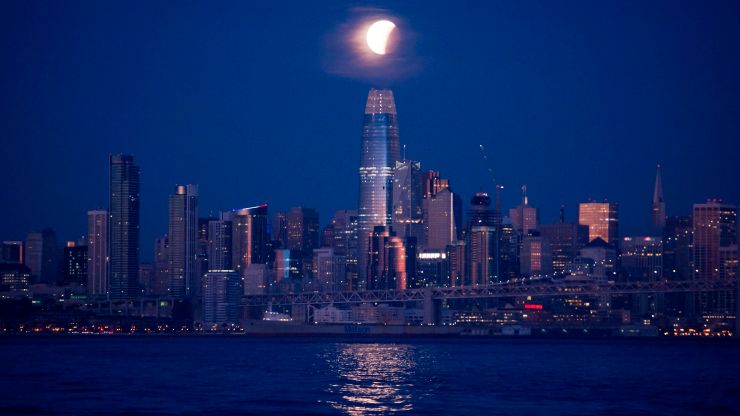The San Francisco skyline, with a super blue blood moon hanging in the center of the sky.