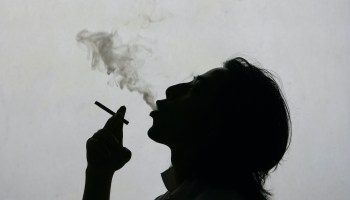 A photo illustration of a man exhaling cigarette smoke.