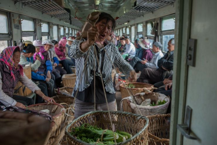 Farmers on board a slow train that runs between Guizhou and Yunnan province in 2014. They could sell their their vegetables from town to town. (Qian Haifeng)