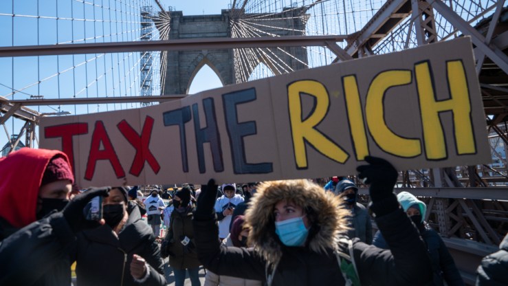 Tax-the-rich protesters march across the Brooklyn Bridge.