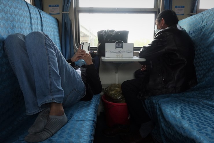 Slow trains have extremely hard seats so when it is not packed, passengers can make themselves comfortable. (Charles Zhang/Marketplace)