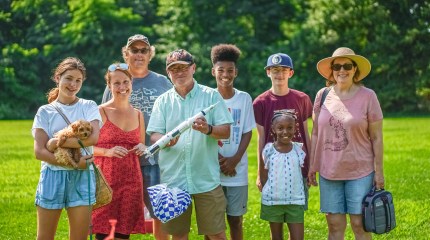 Marketplace listener Ted Dupont poses for a picture with friends and neighbors while holding a model rocket. 