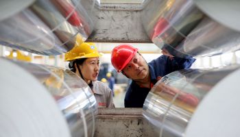 Workers check rolls of sheet aluminum at a factory in Huaibei in China's eastern Anhui province.