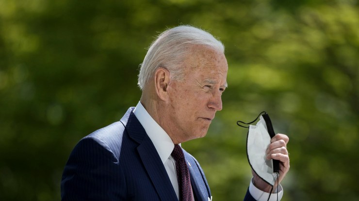 President Joe Biden removes his mask before speaking about updated CDC mask guidance on the North Lawn of the White House on April 27, 2021 in Washington.