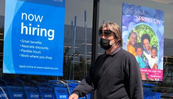 A pedestrian walks by a "now hiring" sign at a Ross Dress For Less store on April 2, 2021 in San Rafael, California.